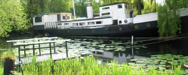 picture of a houseboat on Chichester Canal near its mouth into Chchester Harbour at Birdham Pool, West Sussex